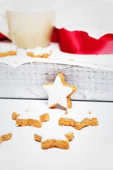 Cinnamon stars in front of a wooden white tray with coffee cup and red ribbon