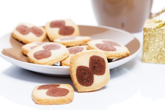 Christmas cookies with plate in front of a cup of coffee with a small Christmas present