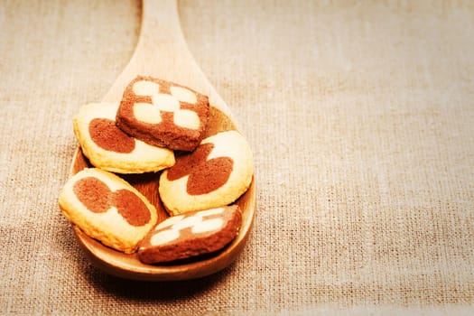 Christmas cookies on wooden spoons on linen fabric