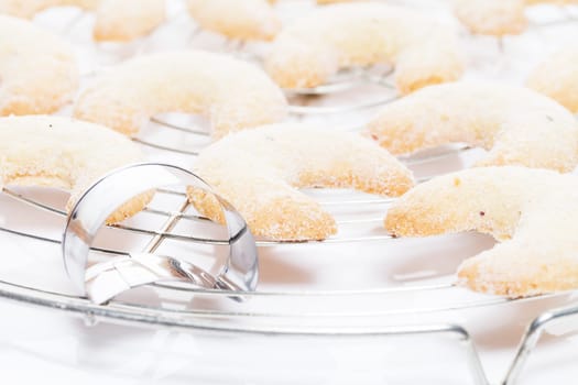 Vanilla crescents on wire rack with cookie cutter