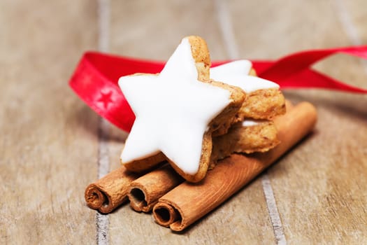 Cinnamon star on cinnamon sticks with red ribbon on wood