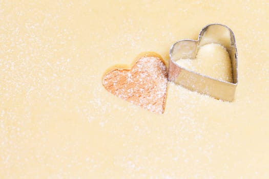 Close-up of hearts with cookie cutter in dough
