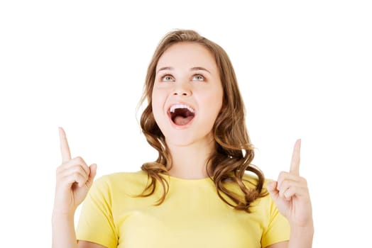 Happy , excited young woman pointing on copy space, isolated on white