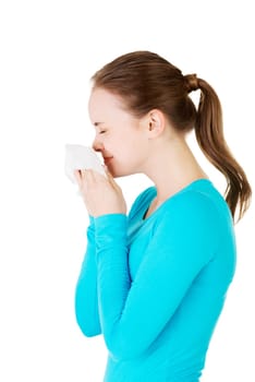 Young woman with tissue - sneezing. Allergy or cold.
