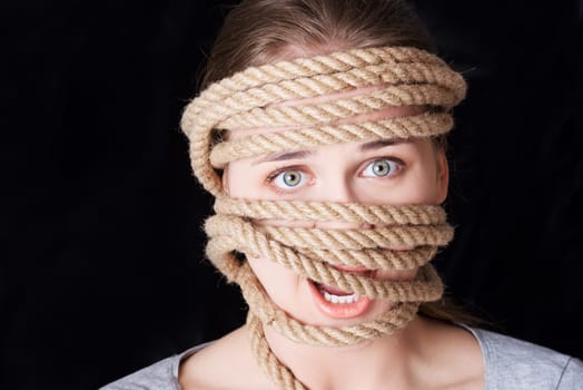 Tied up woman screaming. Violence concept.
