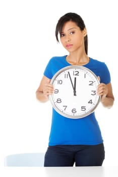 Portrait of shocked woman with clock over white background