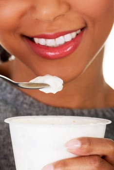 Young beautiful woman eating yogurt as healthy breakfast or snack. Isolated on white