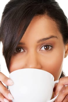 Young woman drinking something from big mug, isolated on white