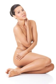 Sexy fit naked woman with healthy clean skin sitting, isolated on white background