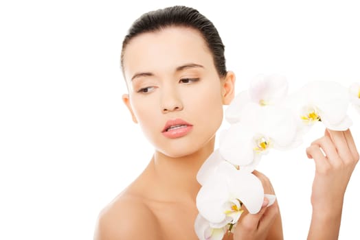 Portrait of beautiful young woman with health skin and with orchid flower. Spa concept.