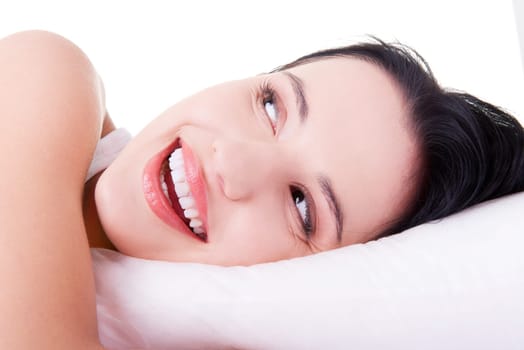 Happy sensual young woman lying in bed and smiling to camera