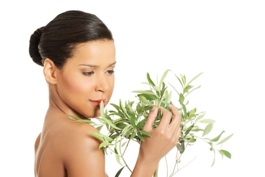 Portrait of beautiful young exotic woman with health skin and with olive tree