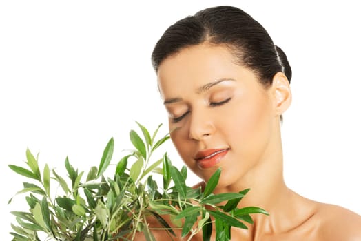 Portrait of beautiful young exotic woman with health skin and with olive tree