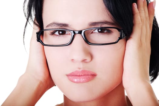 Closeup of frustrated young woman holding her ears, isolated on white