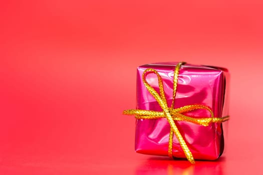 Red glossy gift  on the red background