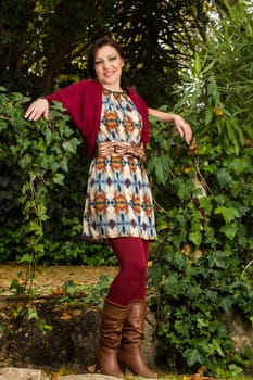 Young beautiful woman with colorful autumn fashionable clothing relaxing on a urban park.