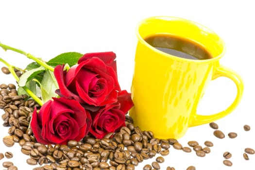 Coffee beans a yellow cup and red roses