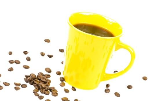 Loose coffee beans and a yellow cup