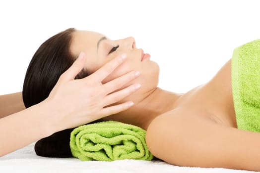 Beautiful young relaxed woman enjoy receiving face massage at spa saloon