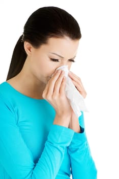 Young woman with tissue - sneezing. Allergy or cold.