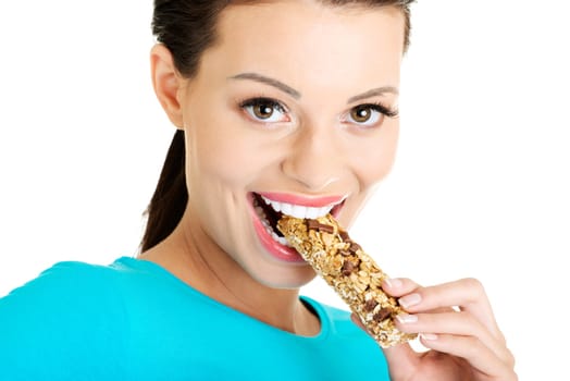 Young woman eating Cereal candy bar, isolated on white