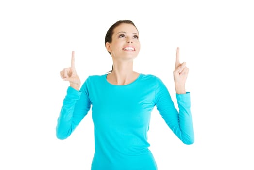Happy , excited young woman pointing on copy space, isolated on white