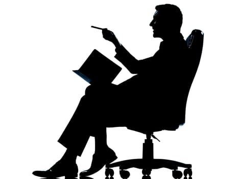 one caucasian business man sitting in armchair silhouette Full length in studio isolated on white background