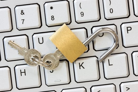 Unlocked padlock with a keys on the computer keyboard