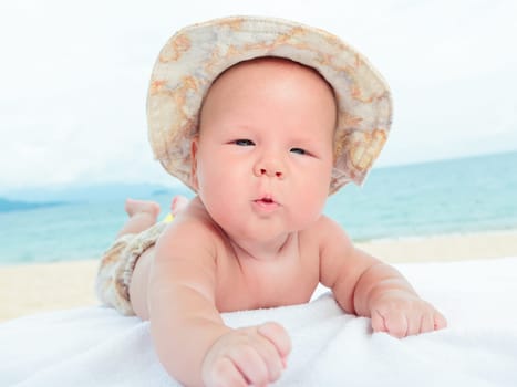 Cure baby laying on the sunbed at the beach