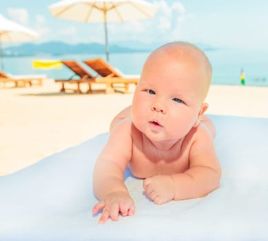 Cure baby laying on the sunbed at the beach