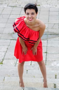Woman in nice red dress smile at square