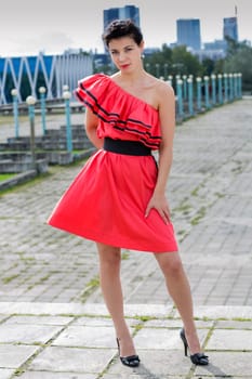 Woman in nice red dress posing at square