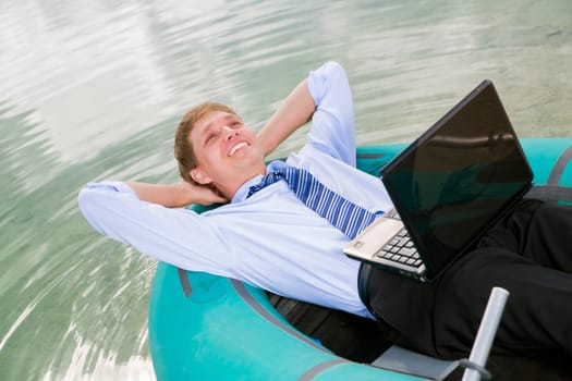 Satisfied man lay in boat and smile sincerely