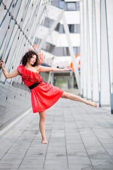 Woman in red dress posing on one leg