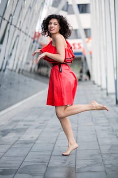 Woman in red dress mimicking run on site