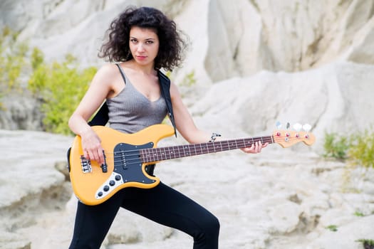 Woman play famous song on yellow bass guitar