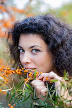 Zoomed view of woman eat gooseberries from branch