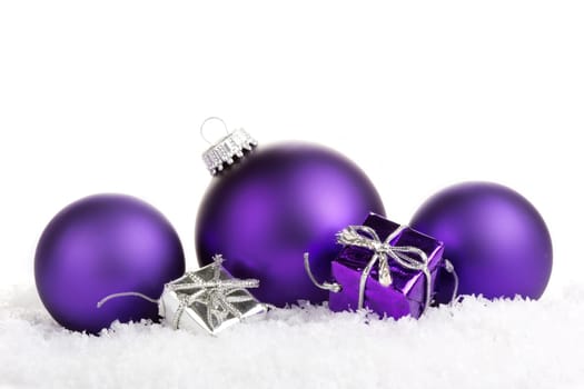 Christmas baubles purple with gifts on artificial snow