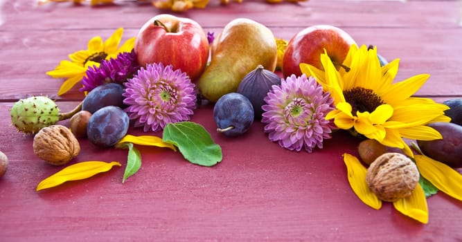 Red background with a frame of autumn fruits and flowers