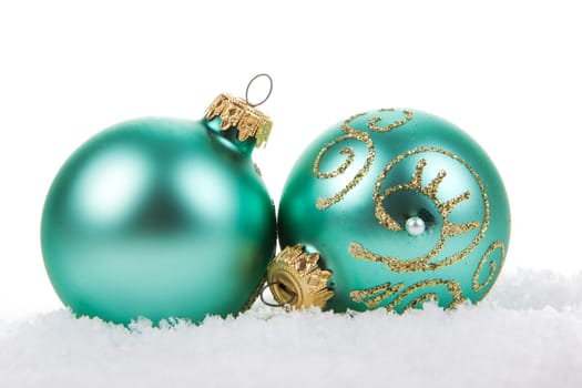 Christmas baubles turquoise on artificial snow with white background