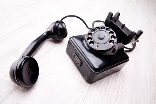 Black rotary dial telephone on a light background