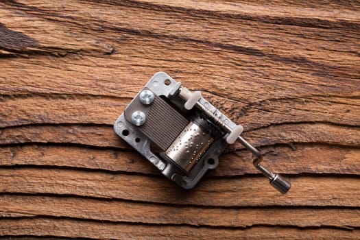 A small metallic carillon on a dark coarse-grained wooden background