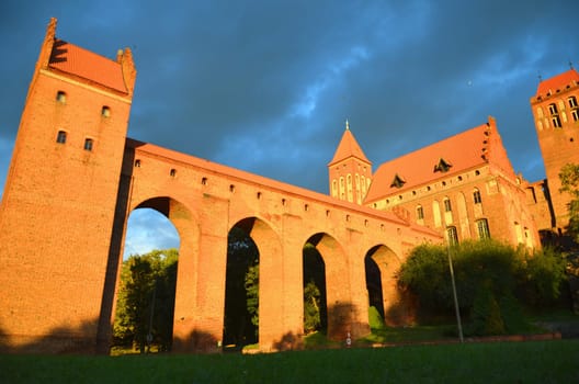 Kwidzyn cathedral in Pomerania region in Poland under dramatic gloomy rainy clouds at sunset