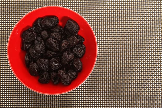 A pile of prunes on a bowl.
