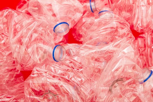 Squeezed bottles of mineral water with a red background.