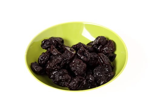 A pile of prunes on a bowl, isolated.