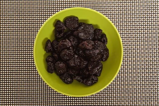 A pile of prunes on a bowl.