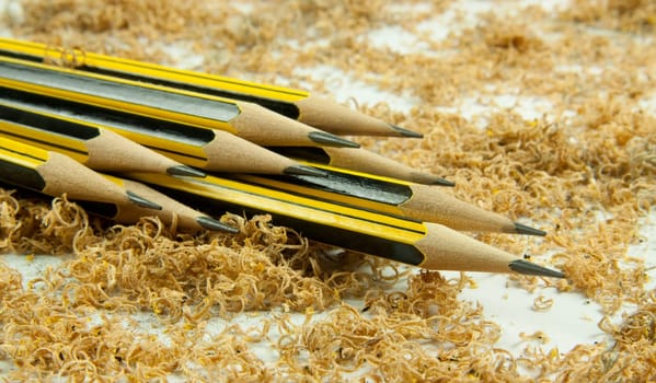 Wooden pencil with shavings isolated on white background