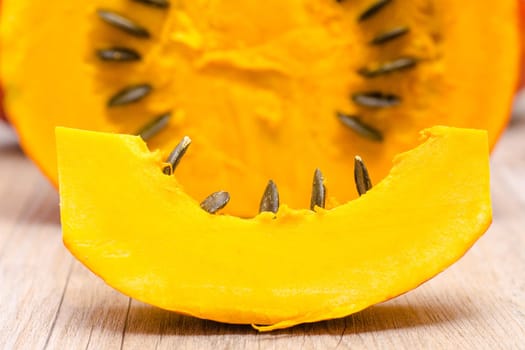 Piece of pumpkin with seeds on a wooden table