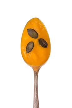 Cube soup and pumpkin seeds on a spoon in portrait format